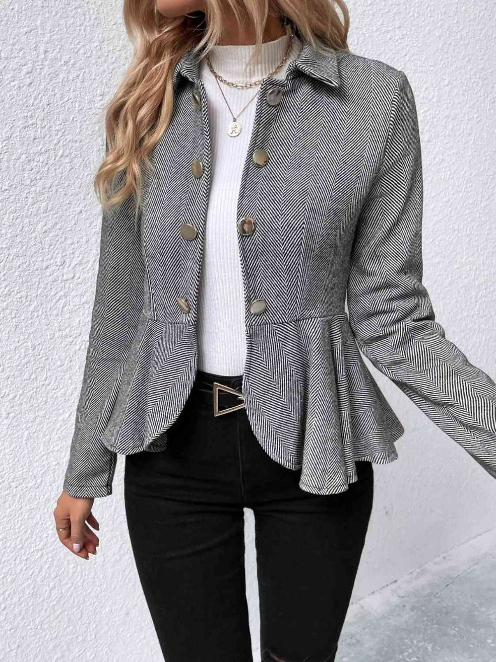 Ruffle hem detail close-up on black collared blazer