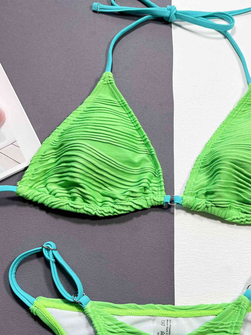 Model in mint green ribbed halter bikini, full length beach look