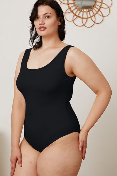 Model wearing white square neck sleeveless bodysuit, full length view